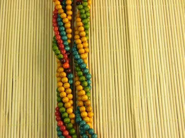 Houten kleurrijke sieraden op bamboe tafel — Stockfoto
