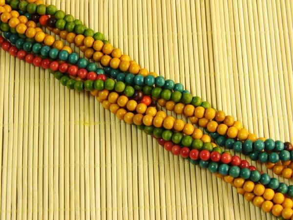 Drewniane kolorowe biżuteria na bambus tabeli — Zdjęcie stockowe