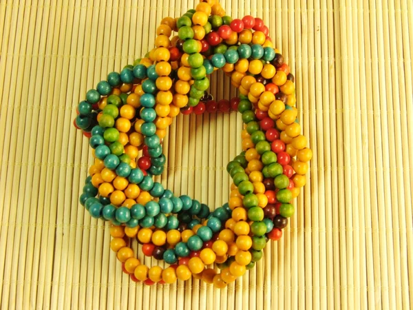 Houten kleurrijke sieraden op bamboe tafel — Stockfoto