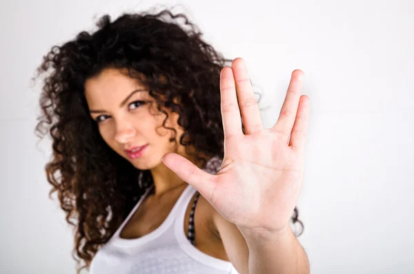 Сurly-haired girl in a white T-shirt shows the sign — Stock Photo, Image