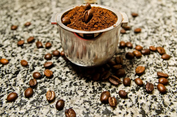 Ground coffee and coffee beans in a metal holder — Stock Photo, Image