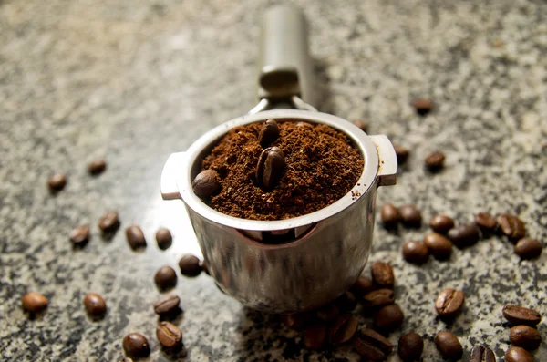 Caffè macinato e chicchi di caffè nel supporto sul mardle tadle — Foto Stock