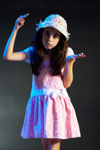 Little girl with a hat making OK sign, black background — Stock Photo, Image