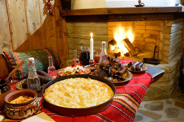 Comida tradicional búlgara na frente de uma chaminé — Fotografia de Stock