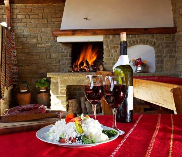 两杯红酒和一瓶在壁炉的前面 — 图库照片