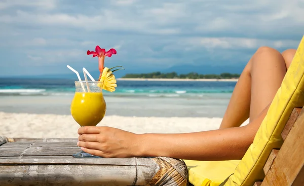 Holding a cocktail on a tropical beach — Stock Photo, Image