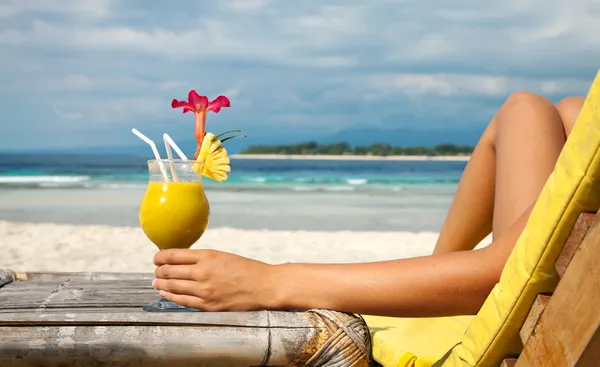 Deținerea unui cocktail pe o plajă tropicală Fotografie de stoc