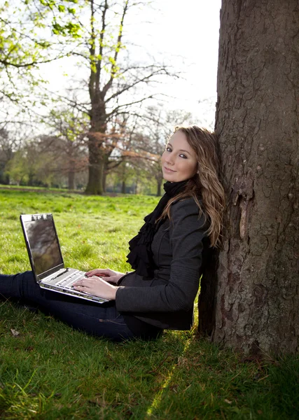 Woman in park with laptop — Stock Photo, Image