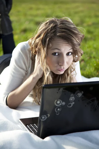 Vrouw in park met laptop — Stockfoto