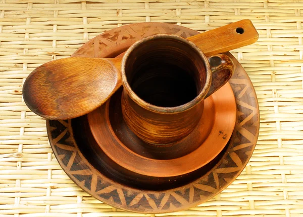Bruin klei cup, platen en houten lepel — Stockfoto