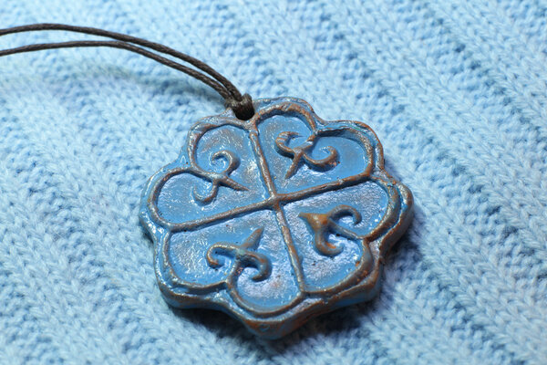 Clay pendant on knitted scarf