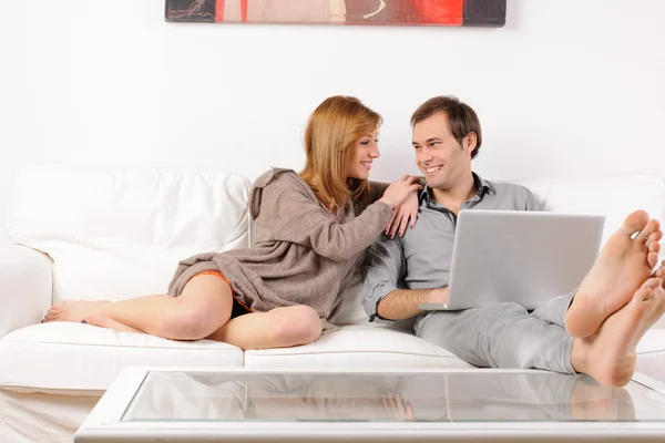 Smiling couple browsing the web at home — Stock Photo, Image
