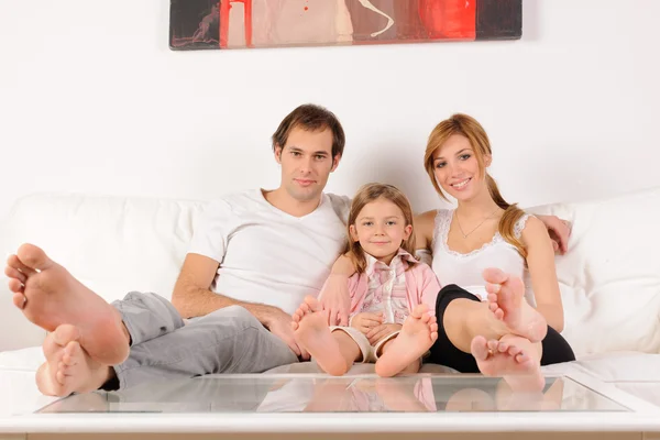女儿和父母坐在沙发上 — 图库照片