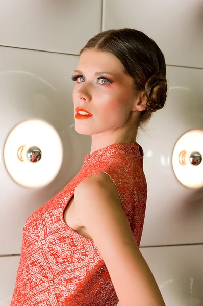 ランプ電球の背後にあるオレンジの服を着ての女の子の肖像画 — ストック写真