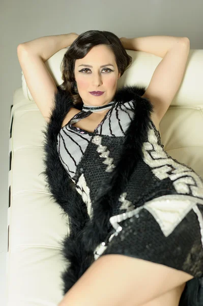 Beautiful portrait of woman dressed in charleston laying, sitti — стоковое фото