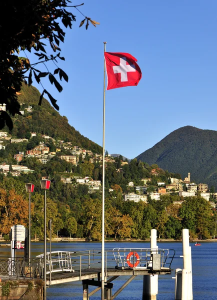 स्वित्झर्लंड मध्ये लुगॅनो लेक स्विस ध्वज — स्टॉक फोटो, इमेज