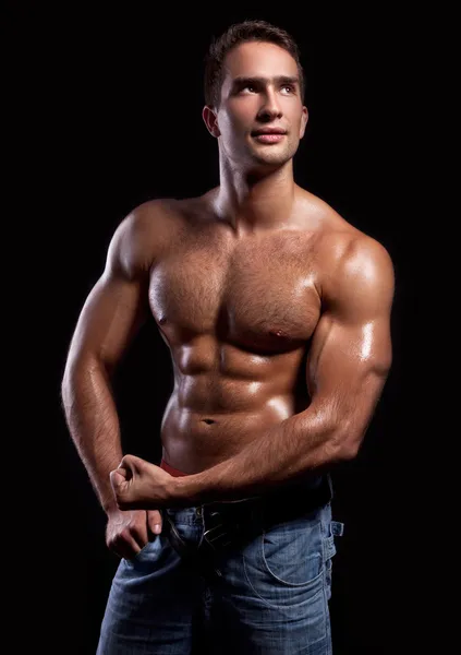 Schöner muskulöser Mann isoliert auf schwarzem Hintergrund — Stockfoto