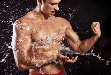 Muscular man having shower clipart