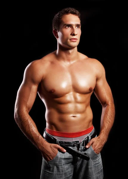 Junger muskulöser Mann isoliert auf schwarzem Hintergrund — Stockfoto