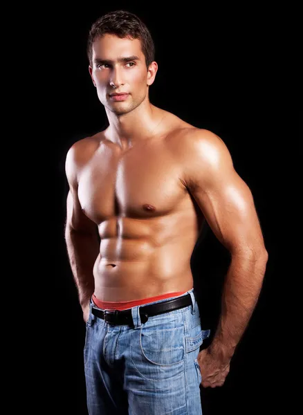 Junger muskulöser Mann isoliert auf schwarzem Hintergrund — Stockfoto