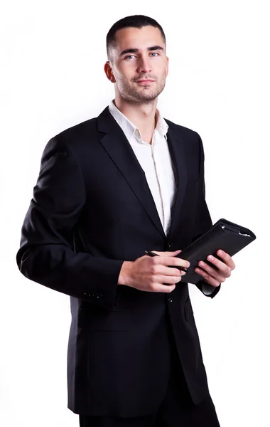 Elegante jovem empresário escrevendo em um caderno isolado em fundo branco — Fotografia de Stock