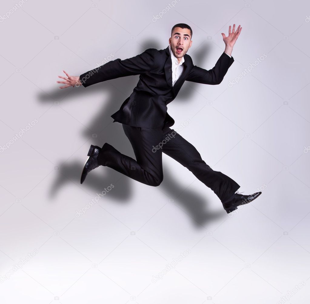 Young handsome businessman jumping
