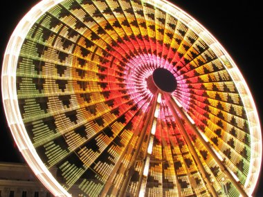 Long exposure of a Ferris Wheel ride at night clipart