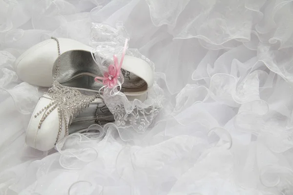 Schuhe und Schmuck mit Strass auf dem Hochzeitskleid. Stockfoto