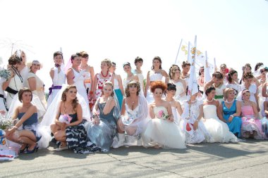 A lot of girls, dressed as a bride on the march 