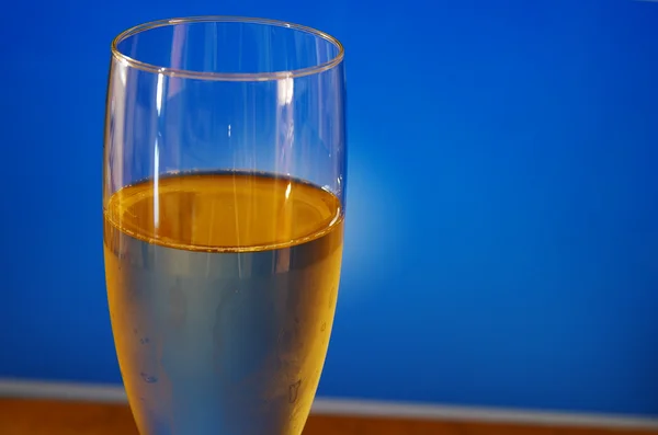 En champagne glas närbild på blå bakgrund — Stockfoto
