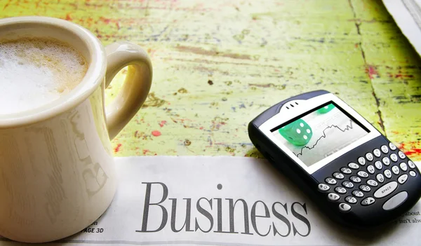 Šálek kávy, mobilní telefon a noviny obchodní sekce — Stock fotografie