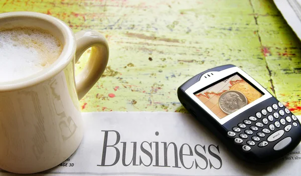 Чашка кофе, сотовый телефон и газетный бизнес-раздел — стоковое фото
