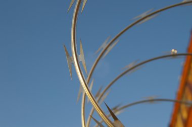 Razor wire closeup on blue sky clipart