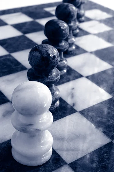 Gruppe von Schachfiguren auf dem Brett, einer an der Spitze — Stockfoto