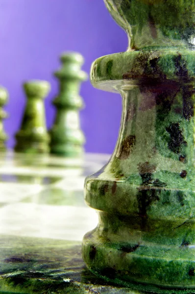 Gruppe von Schachfiguren auf dem Brett, einer an der Spitze — Stockfoto