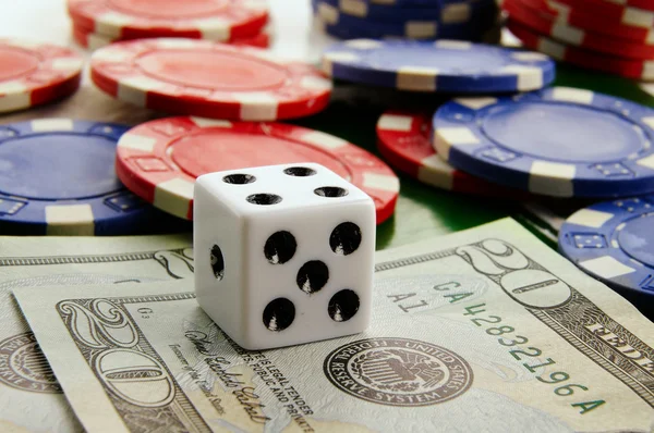 Stacked poker chips and dice with cash — Stock Photo, Image