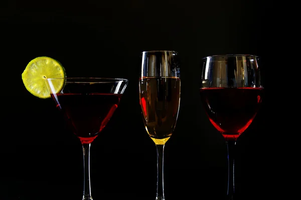 Šampaňské, martini a sklenice na víno na tmavém pozadí — Stock fotografie