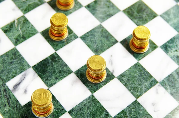 Moedas de euro dispostas num tabuleiro de xadrez como peças — Fotografia de Stock