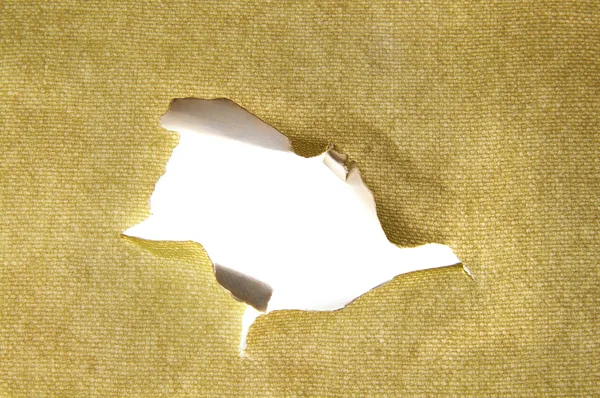 Hole torn in a piece of material, closeup — Stock Photo, Image