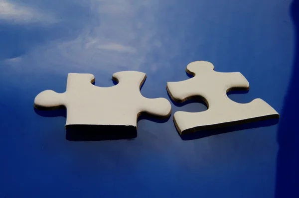 Deux pièces de puzzle s'emboîtant sur bleu — Photo