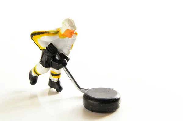 Miniatur-Hockeyfigur mit Puck, auf weiß — Stockfoto