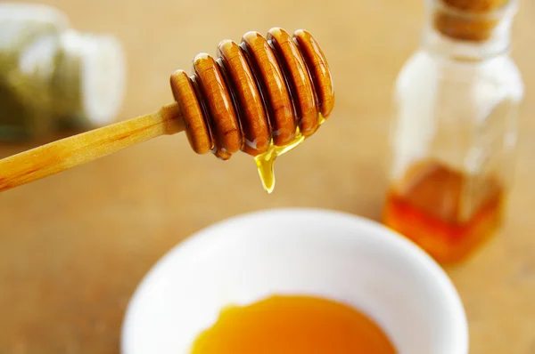 Golden honey dripping into a bowl — Stock Photo, Image