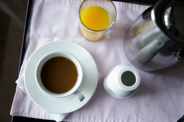 Xícara de café e suco de laranja, em uma bandeja de serviço de quarto — Fotografia de Stock