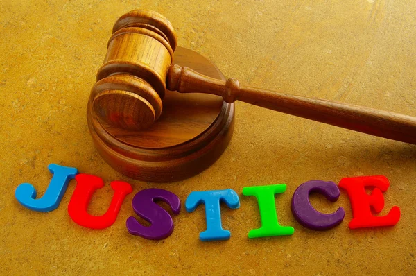 法院的木槌打字母拼写"正义" — 图库照片