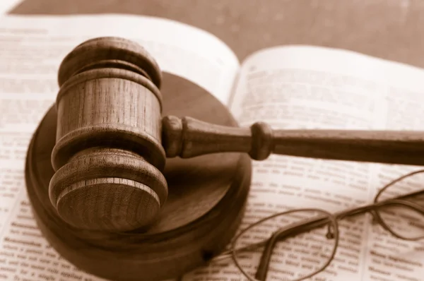 Juízes martelo tribunal em um livro de leis com óculos — Fotografia de Stock