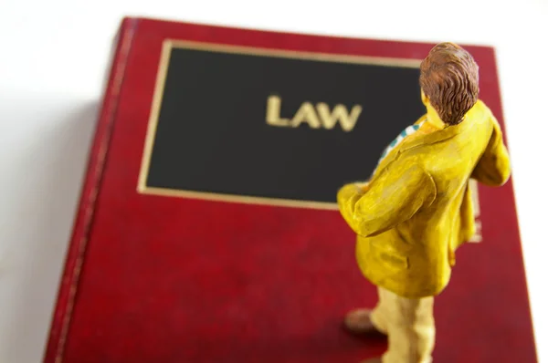 Επιχειρηματικό σχήμα άνθρωπος στέκεται πάνω σε ένα lawbook — Φωτογραφία Αρχείου