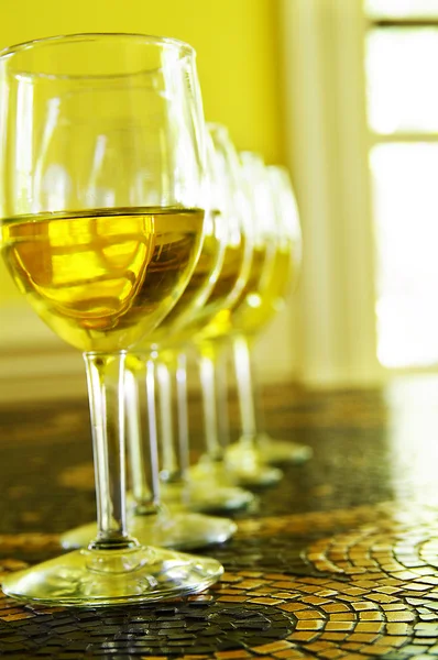 Copos de vinho branco em uma fileira, na mesa de telha — Fotografia de Stock