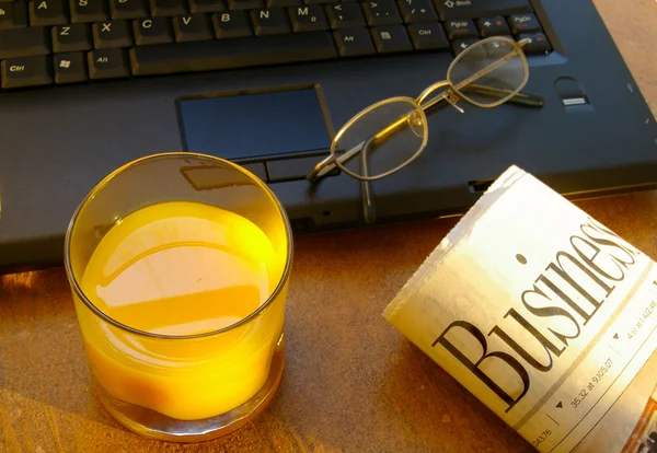 Beker van's ochtends koffie met laptop en krant — Stockfoto