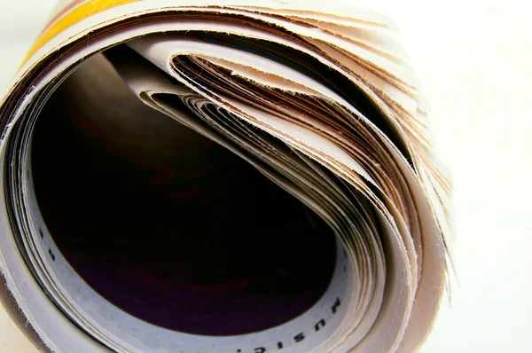Closeup of a rolled up newspaper, on white — Stock Photo, Image