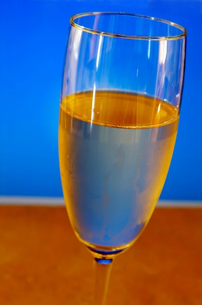 Champagneglas närbild på blå bakgrund — Stockfoto